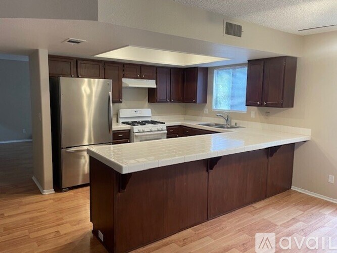 A kitchen with wooden cabinets and a white countertop.