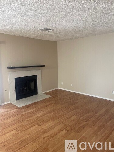 A room with a fireplace and wooden flooring.