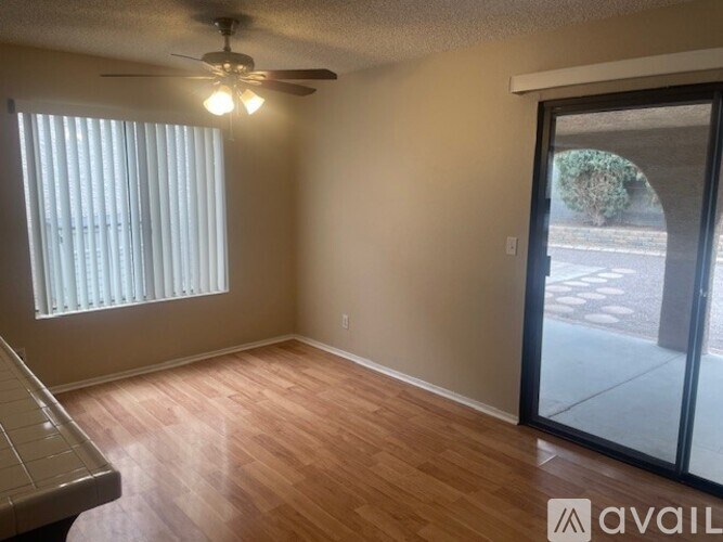 A room with a ceiling fan and sliding glass doors.