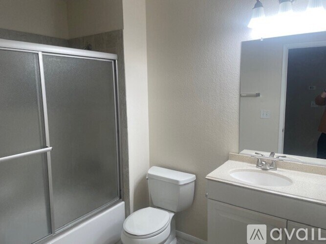 A bathroom with a toilet, sink, and shower.