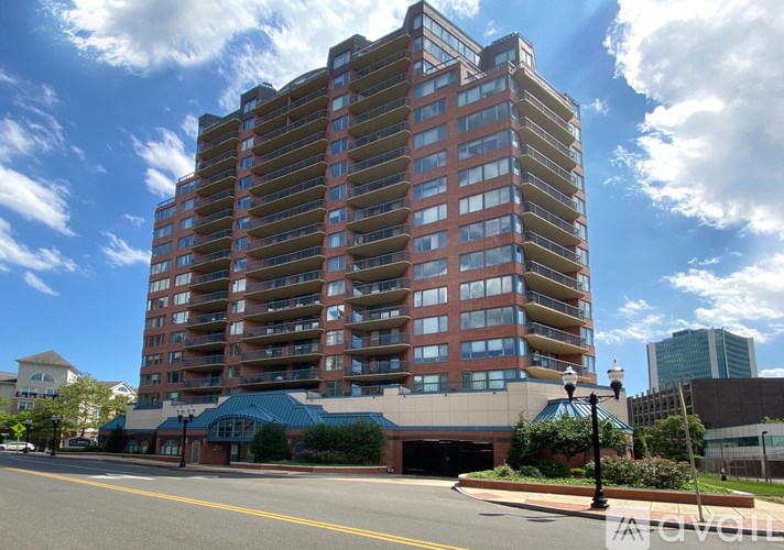 A tall apartment building with a blue awning in front.