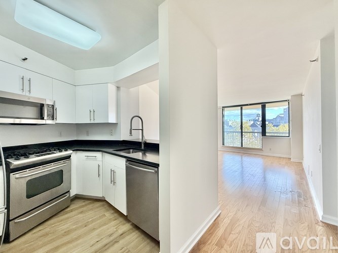 A spacious room with wooden flooring and a sliding glass door.