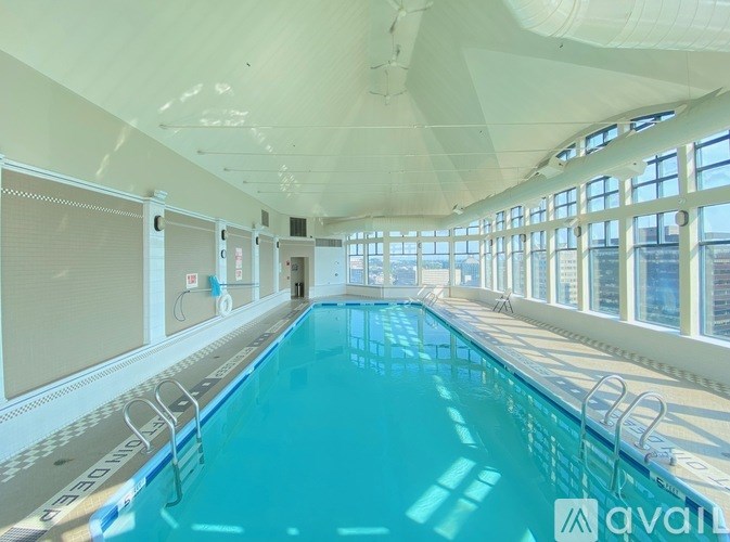 A large indoor swimming pool with a blue tinted water.