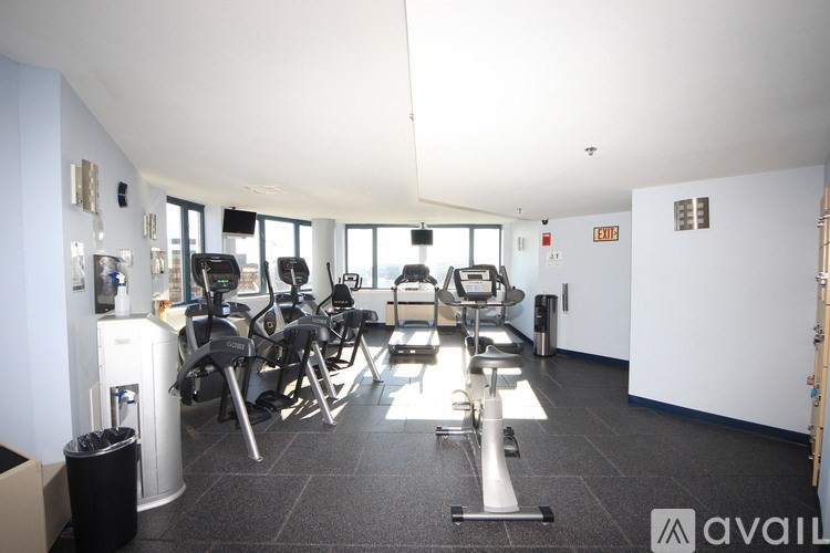 A gym with treadmills, exercise bikes, and weights.
