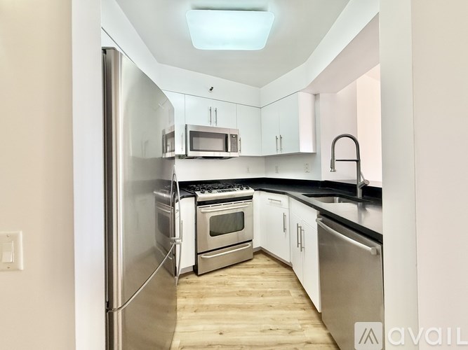 A spacious room with wooden flooring and a large window.