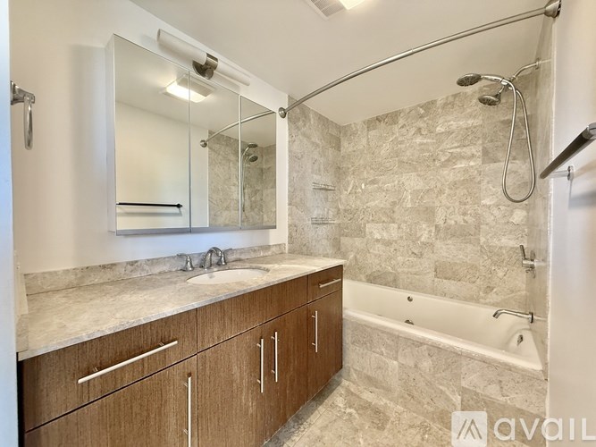 A bathroom with a stone wall and a bathtub.