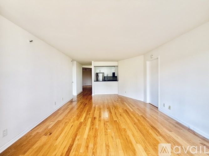 A room with a carpeted floor and a sliding glass door leading to a balcony.