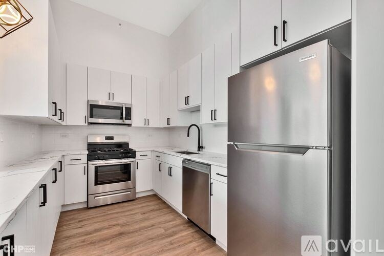 A modern kitchen with stainless steel appliances and white cabinets.