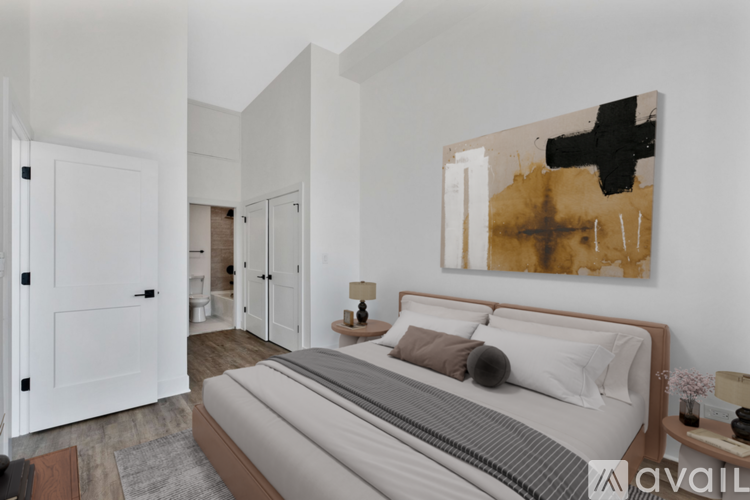 A bedroom with a large bed and a painting on the wall.