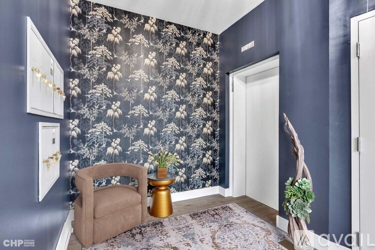 A room with a floral wallpaper and a chair.