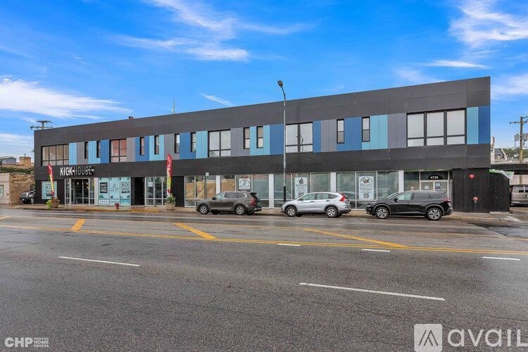 A modern building with a parking lot in front of it.