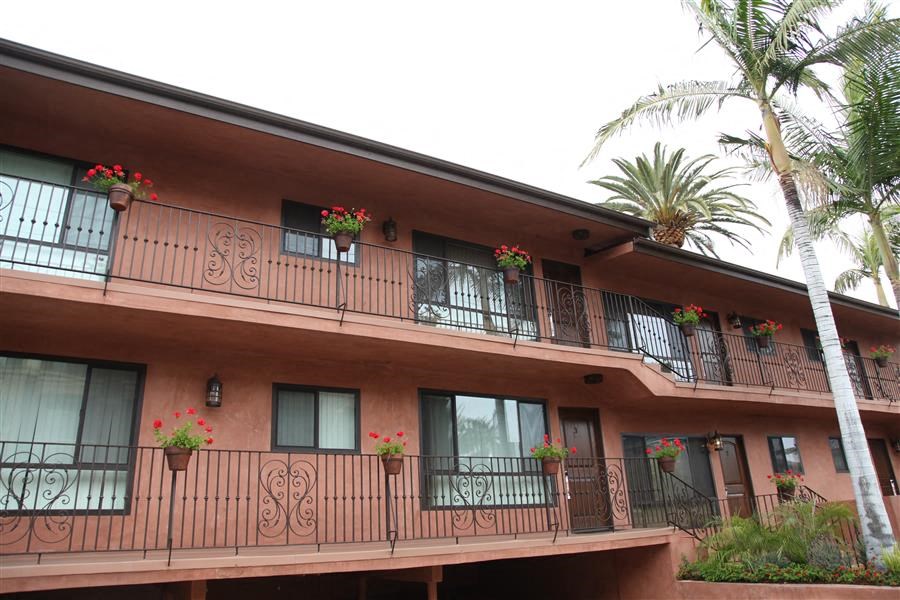 a hotel balcony with flowers and plants on it