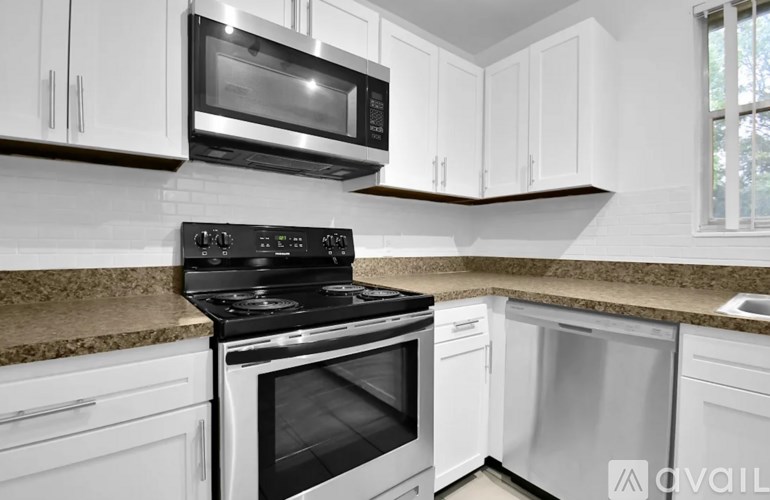 A kitchen with white cabinets and a granite countertop.