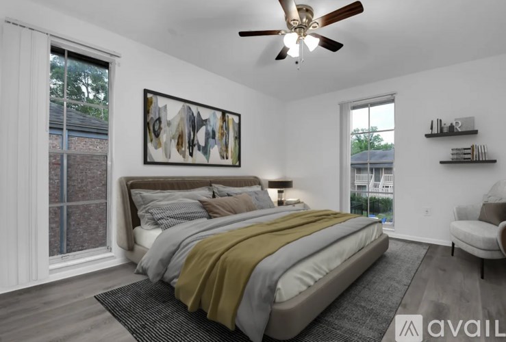 A bedroom with a large bed and a ceiling fan.