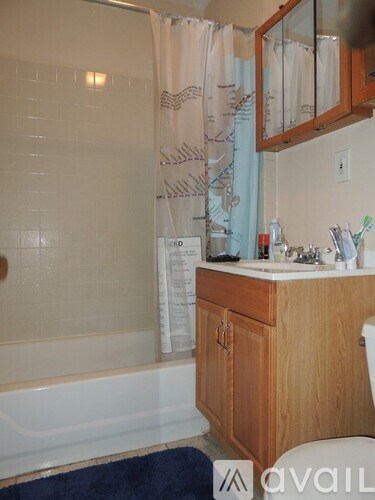 A bathroom with a tub, toilet, and sink.