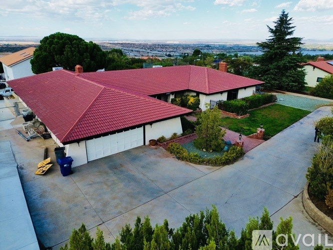 A house with a red roof and a driveway in front.