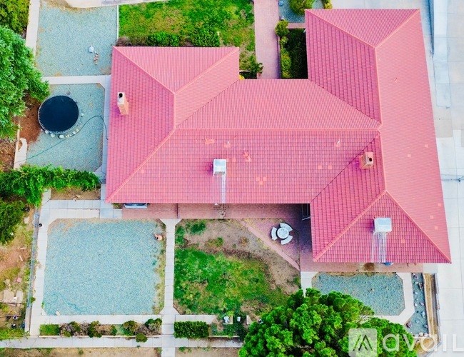 A red building with a pool in front of it.