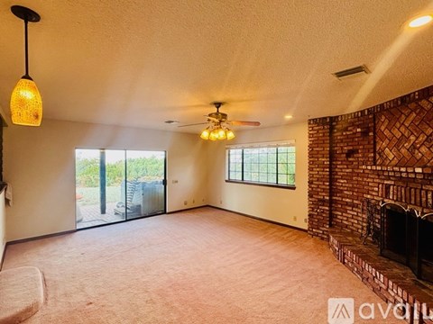 A living room with a fireplace and sliding glass doors.