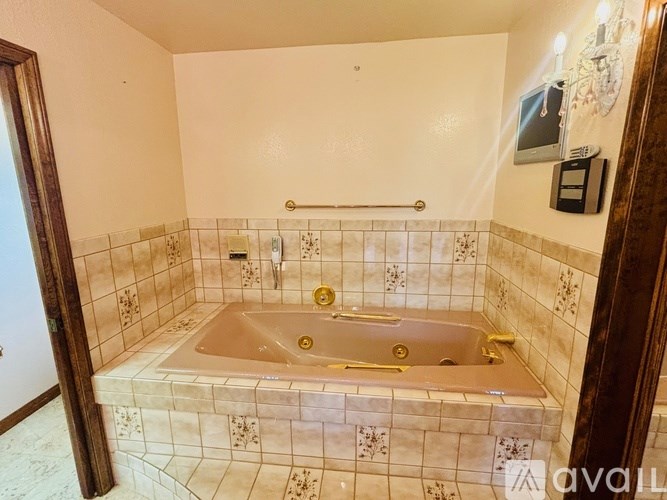 A bathroom with a tiled floor and walls, a bathtub, and a shower.