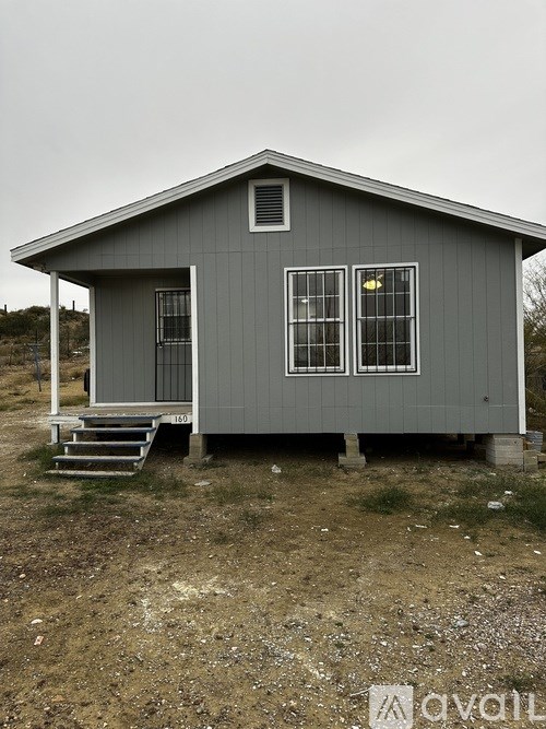 A grey house with a porch and a yellow sign on the window.