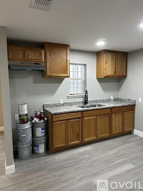 A kitchen with wooden cabinets and a granite countertop.
