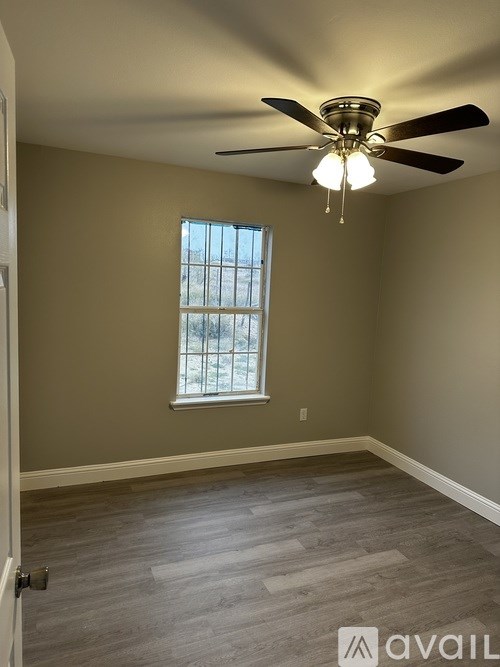 A room with a ceiling fan and a window.