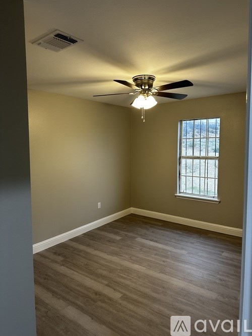 A room with a ceiling fan and a window.