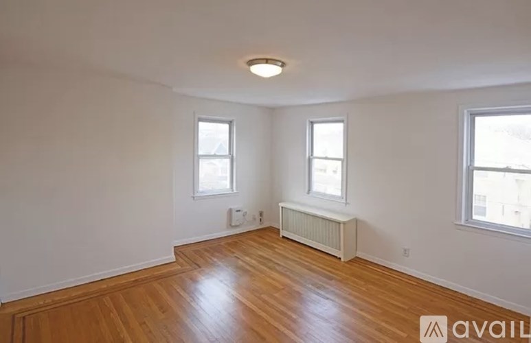 A room with wooden floors and two windows.