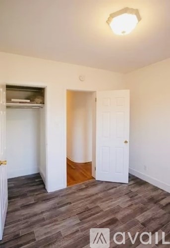 A room with a white door and a grey floor.