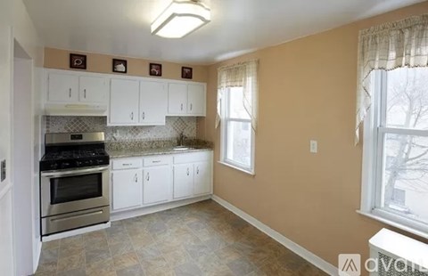 A kitchen with white cabinets and a tiled backsplash.