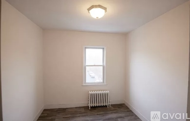 A room with a window and a radiator on the floor.