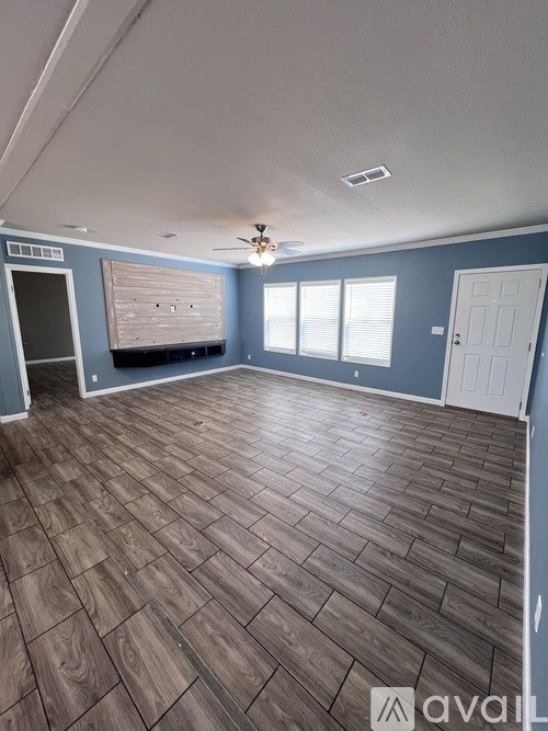 A room with wooden flooring and a ceiling fan.