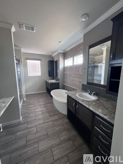A bathroom with a tub, sink, and mirror.
