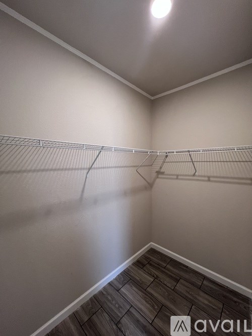 Empty room with a white wall and a wooden floor.