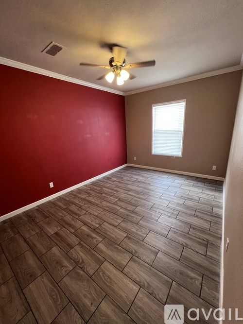 A room with wooden flooring and a ceiling fan.