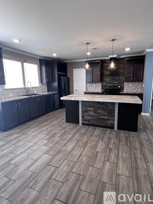 A kitchen with a wooden floor and a stone backsplash.