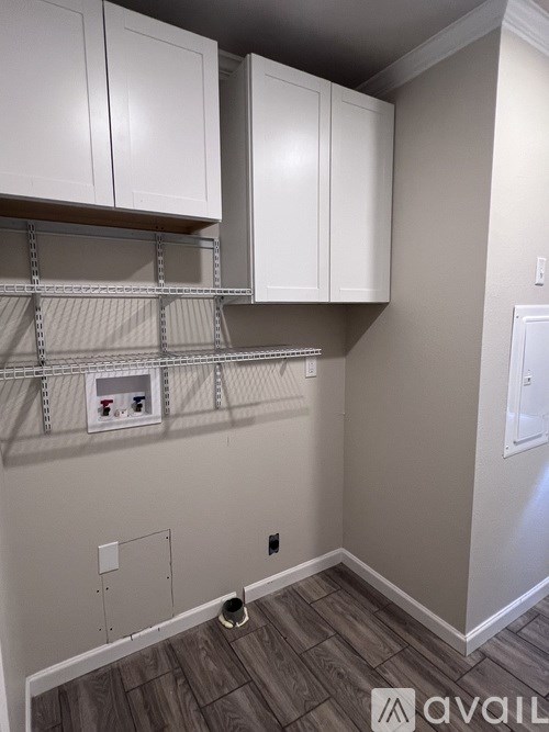 A room with white cabinets and a grey wall.