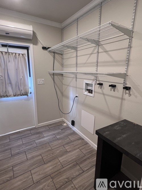 A room with a wall-mounted shelf and a wooden floor.