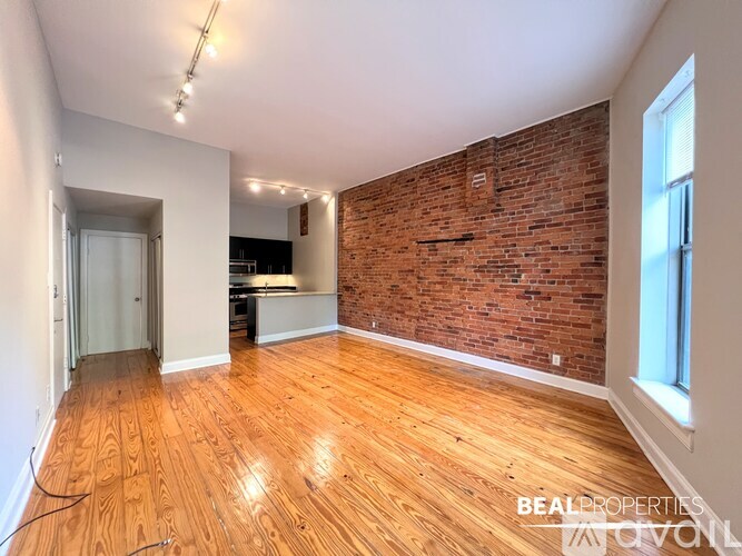 A room with wooden flooring and white walls.