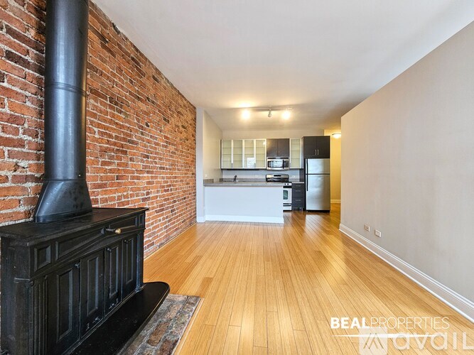 A living room with a fireplace and wooden floors.