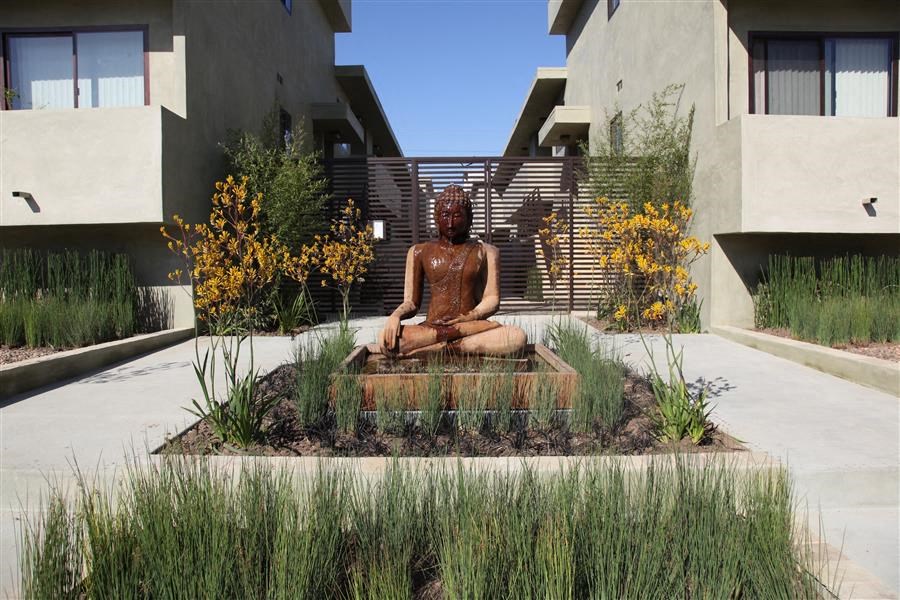 a statue of a person sitting in the middle of a garden
