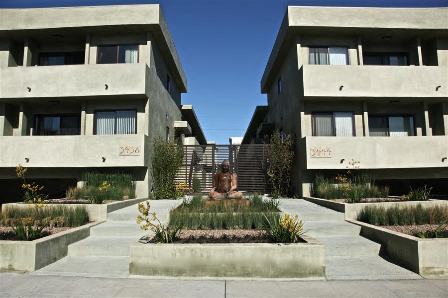 a statue in the middle of a courtyard between two apartment buildings