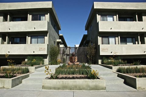 a statue in the middle of a courtyard between two apartment buildings