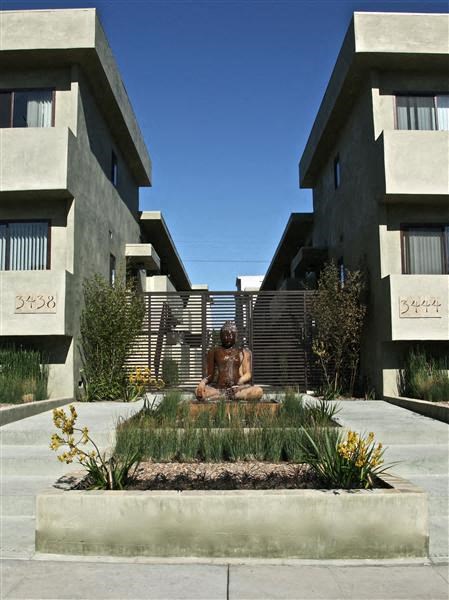 a statue of a person sitting in the middle of a courtyard