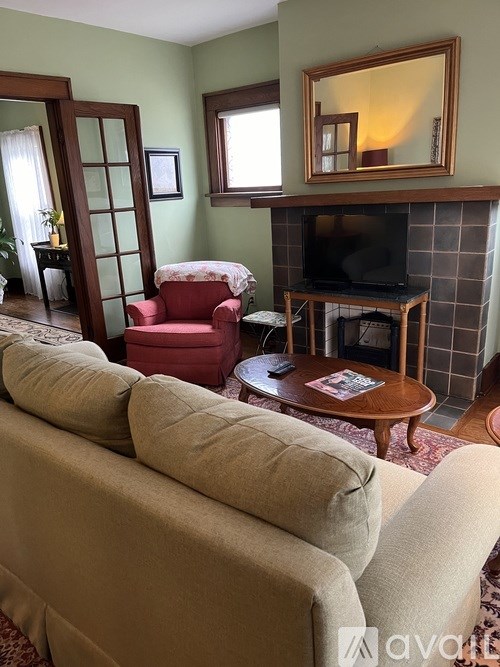 A bathroom with a toilet, sink, and window.