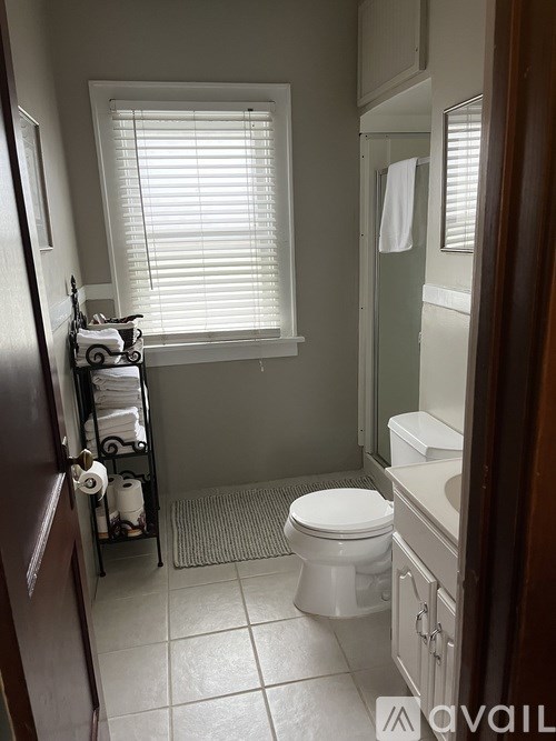A white toilet in a bathroom with a towel hanging on the wall.