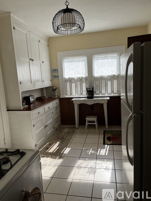 A kitchen with white cabinets and a stove top oven.