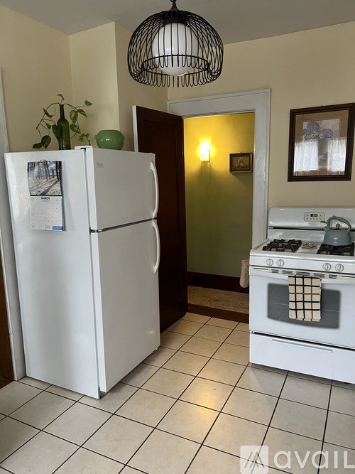 A kitchen with white cabinets and a rug on the floor.
