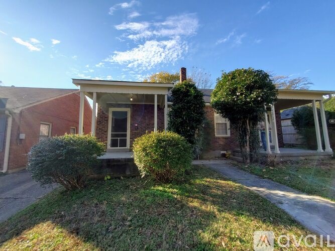 A house with a red brick exterior and a white porch.
