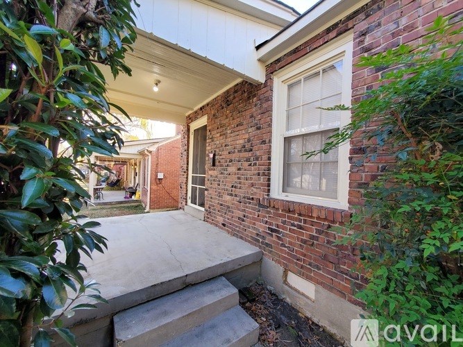 A brick house with a white window and a door.